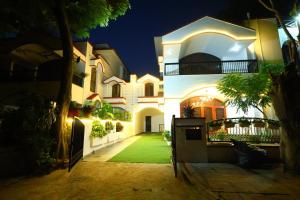 a large white house with a green yard at night at Imperial Home Stayz in Gurgaon