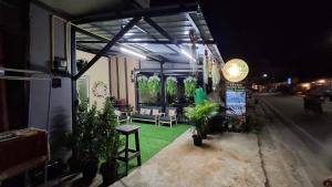 a patio with plants and chairs in a building at night at So Cute Hostel, Kai Bae, Koh Chang in Trat