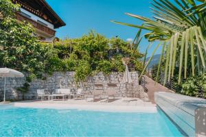 a swimming pool next to a building with a wall at Oberegghof Ferienwohnung Laugen in Rifiano