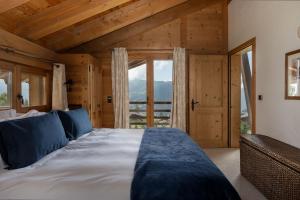 a bedroom with a large bed in a room with windows at Chalet Jenna Verbier - by EMERALD STAY in Verbier +22 photos