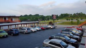 a parking lot with cars parked in front of a building at Red Carpet Inn - Blacksburg in Blacksburg
