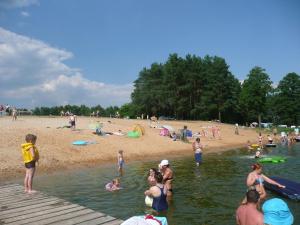 un groupe de personnes dans l'eau d'une plage dans l'établissement Mazurska Perła, à Jaśkowo