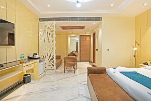 a hotel room with a bed and a kitchen at The Riverstone Inn in Greater Noida +93 photos