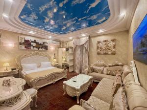 a bedroom with a bed and a couch and a room with a ceiling at Hotel Agava in Tbilisi City