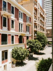 an apartment building with trees in front of it at Saint J Hotel by Brassbell in Cairo
