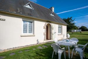 une table et des chaises devant une maison blanche dans l'établissement Maison Plouha proche plage, à Plouha