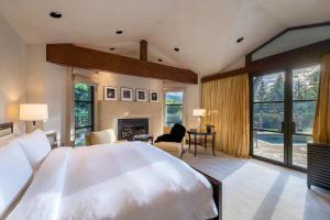 a bedroom with a large white bed and a fireplace at Villa Noor in Aspen