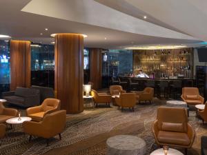 a lobby of a hotel with chairs and a bar at Novotel Kuala Lumpur City Centre in Kuala Lumpur