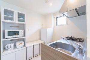 a kitchen with a sink and a refrigerator at 8 min to Nagoya Station Great access Sleeps 6 in Nagoya +42 photos