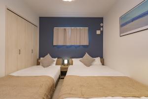 two beds in a small room with blue walls at 8 min to Nagoya Station Great access Sleeps 6 in Nagoya