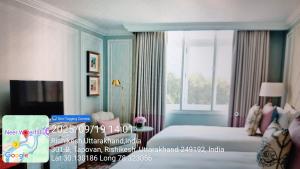 a hotel room with a bed and a window at Hotel Kavya in Rishīkesh