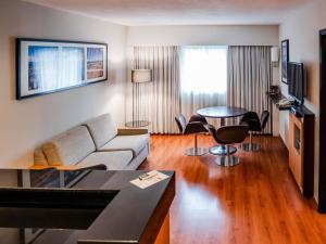 a living room with a couch and a table at Novotel Lima San Isidro in Lima