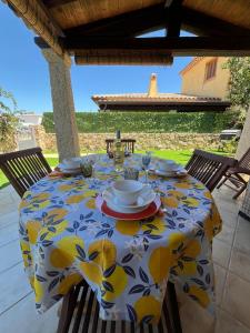 a table with a yellow and white tablecloth on a patio at Casa Villetta Vacanze Budoni in Budoni
