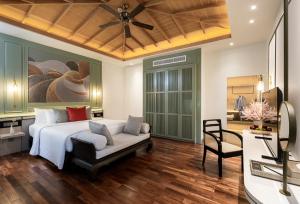a bedroom with a bed and a chair and a desk at La Solaya Khao Lak in Khao Lak