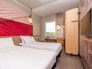 a hotel room with two beds and a window at ibis Campo Grande in Campo Grande