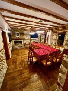 een eetkamer met een rode tafel en houten stoelen bij Vila Martina in Smilyan