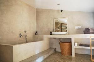 a bathroom with a tub and a sink and a mirror at Casa Merceditas in Corçà