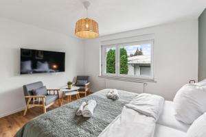 a bedroom with a bed with two towels on it at Modernes 6-Betten-Apartment mit Balkon und Parkplatz - zentrale Lage in Aalen