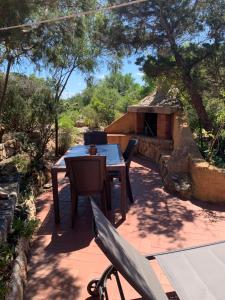 a table and chairs on a patio with a fireplace at Casa MìMì in La Maddalena