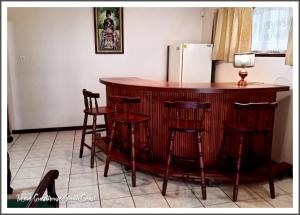 a kitchen with a bar with stools and a refrigerator at Ingwe Guest House and Self Catering in Durban +3 photos