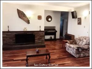 a living room with a couch and a flat screen tv at Ingwe Guest House and Self Catering in Durban