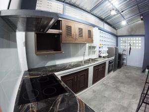 a kitchen with wooden cabinets and a black counter top at Krabi Top Sea Hill Villa in Klong Muang Beach