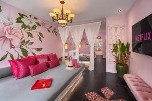 sala de estar con paredes rosas y sofá en PinkCoco Uluwatu - Constant Surprises & for Cool Adults Only, en Uluwatu
