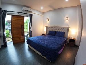 a bedroom with a bed with a blue comforter at Krabi Top Sea Hill Villa in Klong Muang Beach