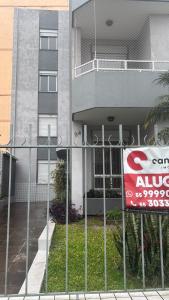 サンタ・マリアにあるLoft ao lado shopping royalの建物の前の柵に掲げられた看板