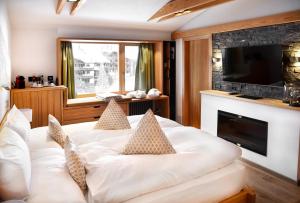 1 dormitorio con cama blanca y chimenea en The Dom Hotel Saas-Fee operated by Dorint, en Urnäsch