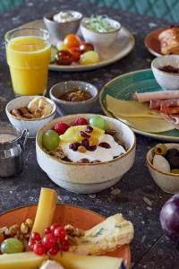 una mesa cubierta con tazones de comida y platos de comida en The Dom Hotel Saas-Fee operated by Dorint, en Urnäsch