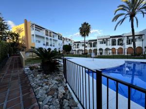 a resort with a swimming pool and some buildings at Apartamento Marinas de Nerja in Nerja