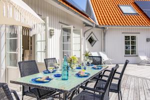 une table et des chaises sur une terrasse avec une table et des boissons dans l'établissement Vacation Dream with Sea View, Sauna, Patio & BBQ, à Glommen