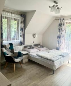a bedroom with two twin beds and a chair at Pokoje Gościnne Nowa Grań in Zakopane