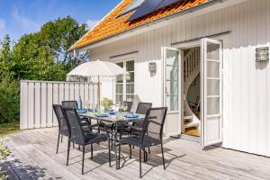 une table avec des chaises et un parasol sur une terrasse dans l'établissement Vacation Dream with Sea View, Sauna, Patio & BBQ, à Glommen