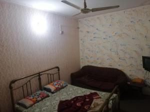 a bedroom with a bed and a couch and a wall at Marhaba Hotel in Dargai