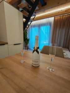 a bottle of wine sitting on a table with two glasses at Bungalov Damiano's 9 in Podbrdo