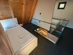 a small room with a bed and a glass case at Bungalov Damiano's 9 in Podbrdo