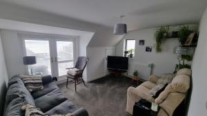 Una sala de estar con dos sofás y un televisor. en Hill Head - Large cottage with sea views - 5 bed, slp 10, en Hill Head