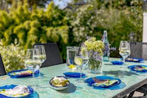 une table avec des verres et des assiettes de nourriture dans l'établissement Vacation Dream with Sea View, Sauna, Patio & BBQ, à Glommen