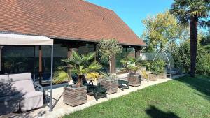 a house with a pavilion with palm trees in a yard at Les 2 Ginkgos près de Beauval in Seigy