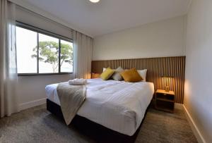 a bedroom with a large bed and a large window at Lufra Beachside Hotel in Eaglehawk Neck +38 photos