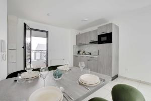 ein Esszimmer mit Tisch und Stühlen und eine Küche in der Unterkunft Elegant apartment - 2BDR-6P - near Paris & La Defense in Puteaux