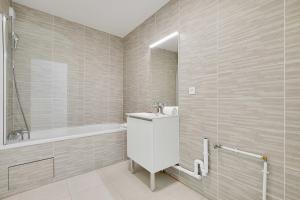 ein Badezimmer mit Waschbecken und Badewanne in der Unterkunft Elegant apartment - 2BDR-6P - near Paris & La Defense in Puteaux