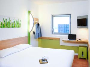 une chambre avec un lit et un bureau avec un ordinateur portable dans l'établissement ibis budget Birmingham Airport Terminal Building - NEC, à Bickenhill