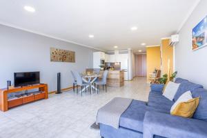 a living room with a blue couch and a table at Estrela house II Calheta Madeira in Calheta
