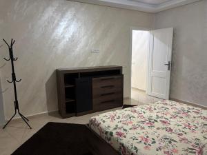 Un dormitorio con una cama y un televisor en una pared. en California E, en Kenitra