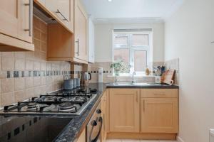 eine Küche mit Herd und Spüle in der Unterkunft Sea Breeze in Ulwell