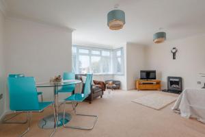 ein Wohnzimmer mit einem Glastisch und blauen Stühlen in der Unterkunft Sea Breeze in Ulwell