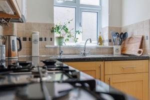 eine Küche mit Spüle und Fenster in der Unterkunft Sea Breeze in Ulwell + 9 Fotos